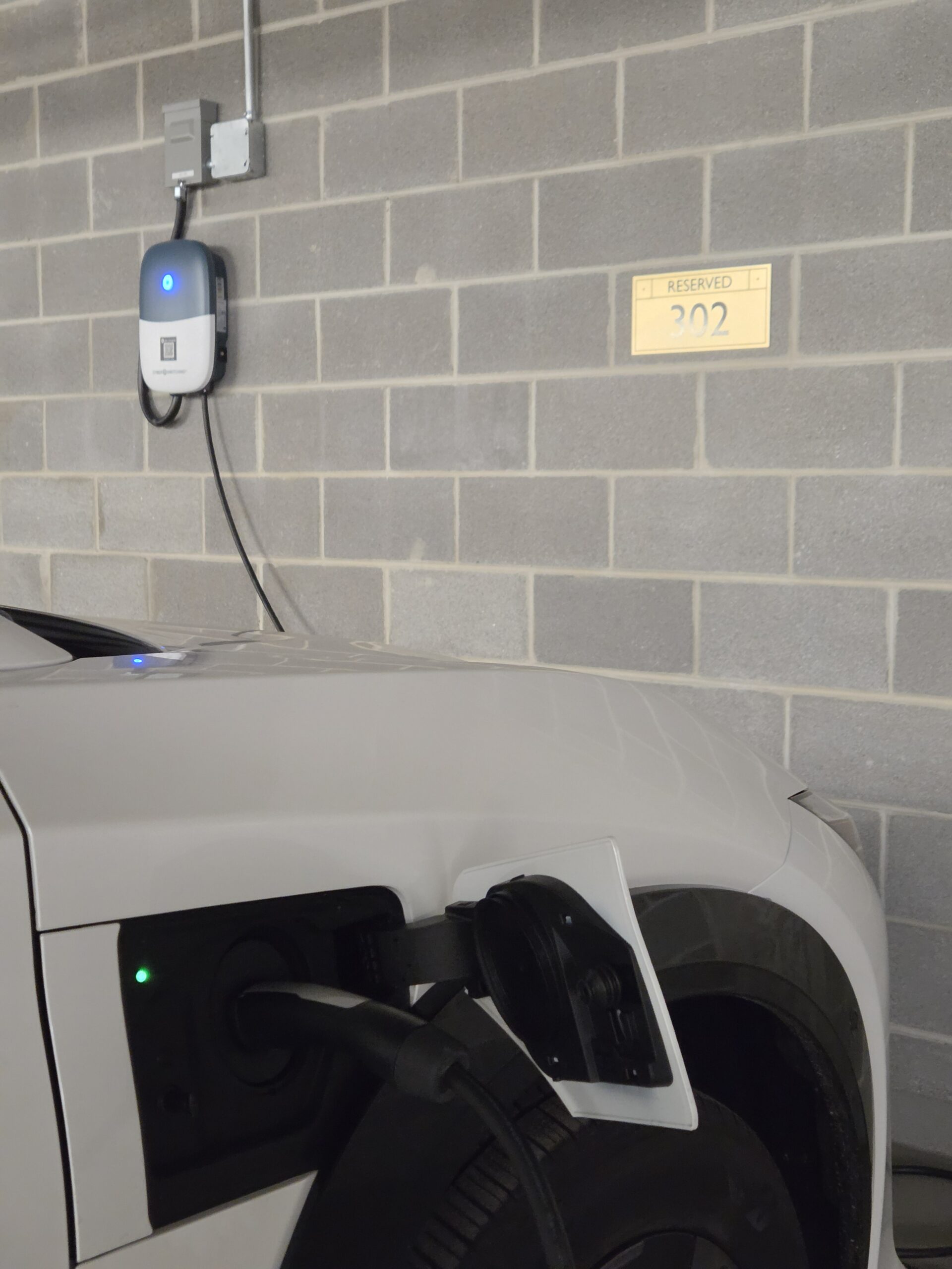 CyberSwitching CSE1 charger actively charging a vehicle at reserved stall 302 in the RiverView Condos garage